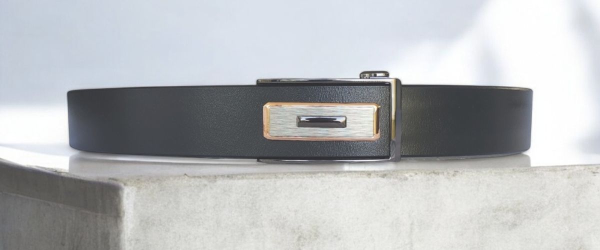 tuckaway ratchet belt with gold trim on concrete bench- BeltUp Leather Co.