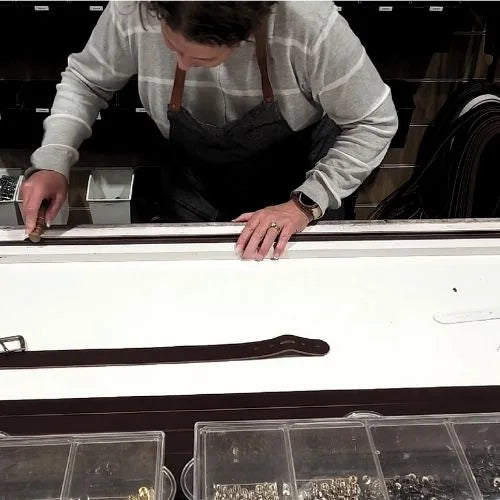 Person polishing leather belt  in a workshop setting